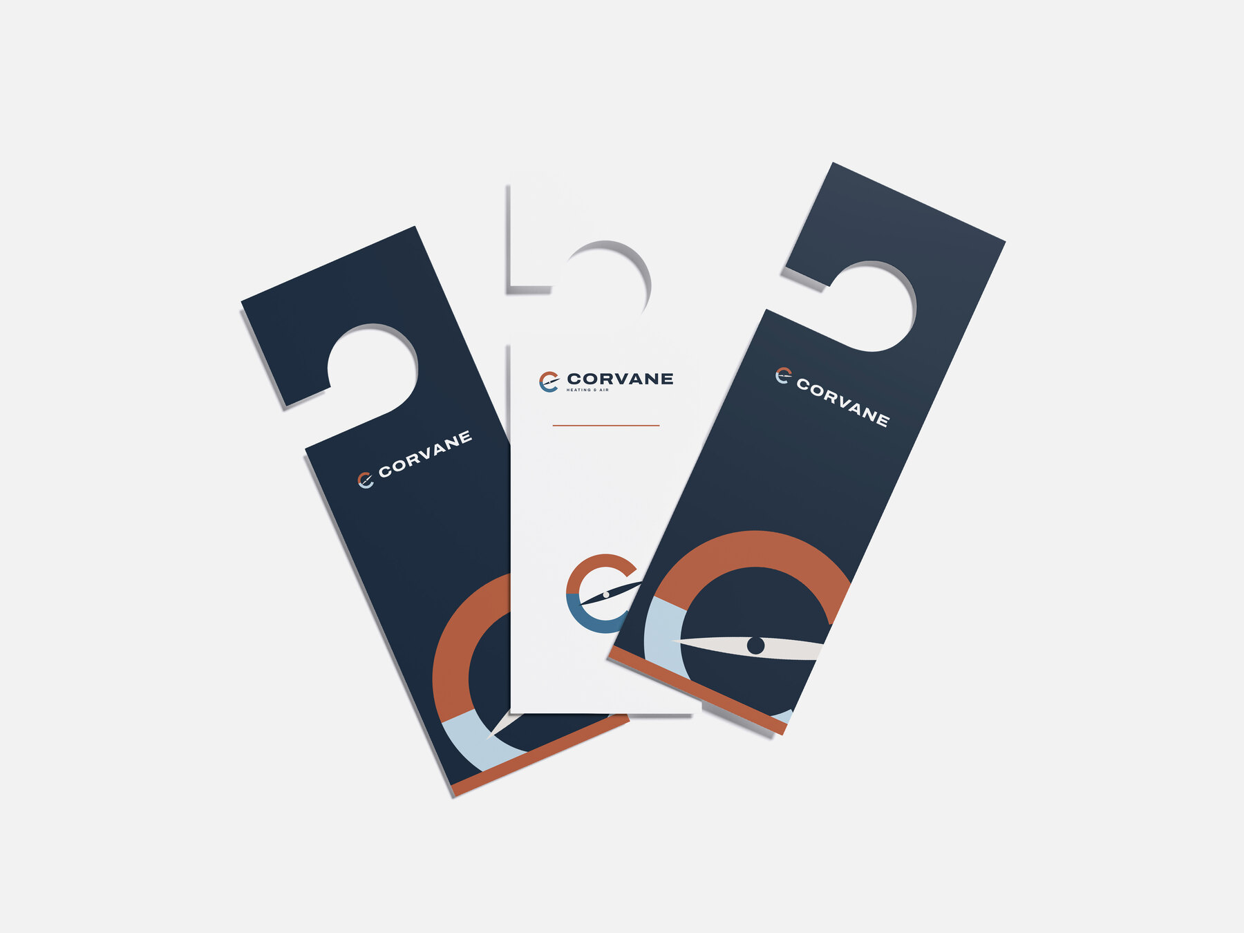 Concept brand: Corvane Heating & Air (fictional). Corvane door hangers we designed, fanned out on a light grey surface.