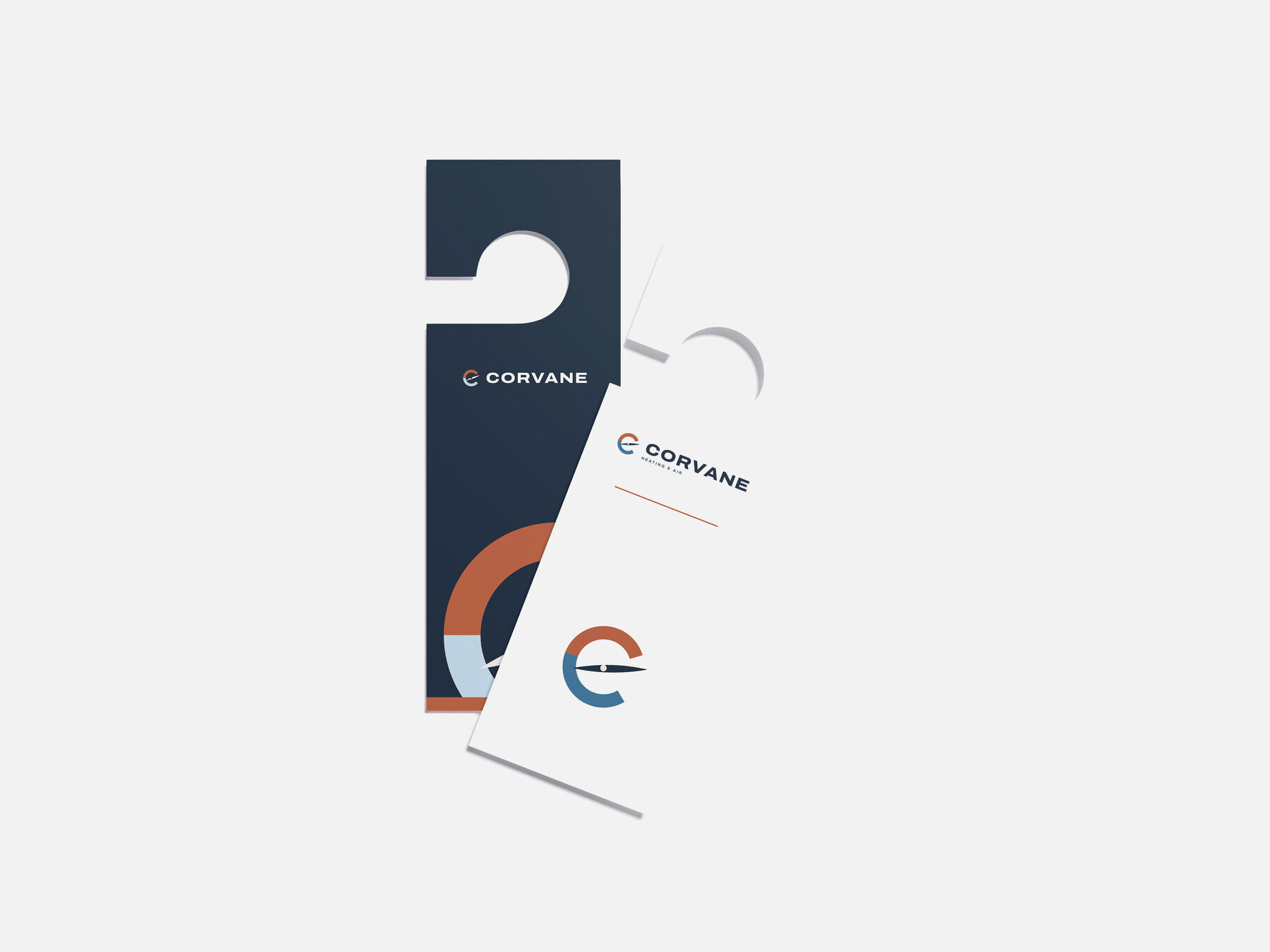 Concept brand: Corvane Heating & Air (fictional). Corvane door hangers we designed, navy and white, on a light grey surface.